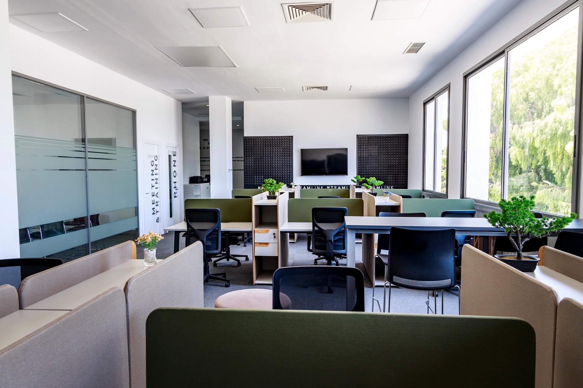 Open coworking floor with desk pods and meeting and training zones